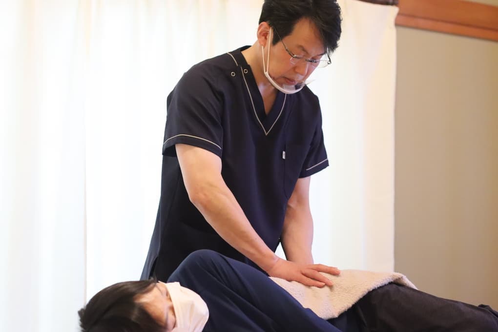 横向きのお客様の仙腸関節を施術している様子