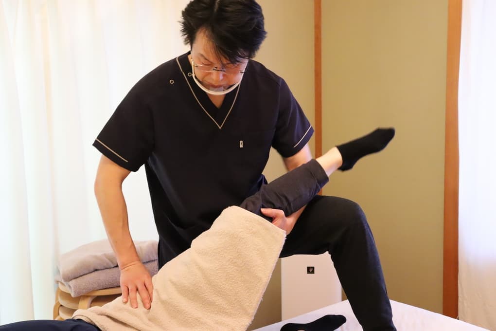 お客様の足や股関節の動きを調整している様子